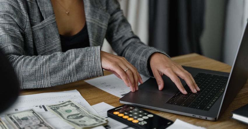 Budget Table - A Woman in Plaid Blazer Using Her Laptop