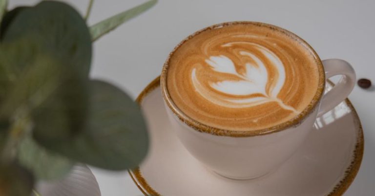 Coffee Myths - A cup of coffee with a leaf and a cookie