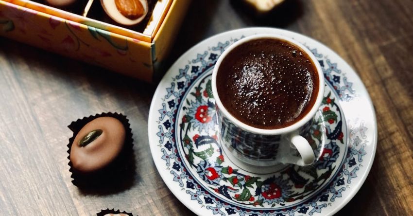 Variety Of Coffee Drinks - A Variety of Chocolates beside a Cup of Coffee