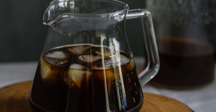 Cold Brew Coffee - Clear Glass Pitcher With Cola and Ice on Wooden Chopping Board