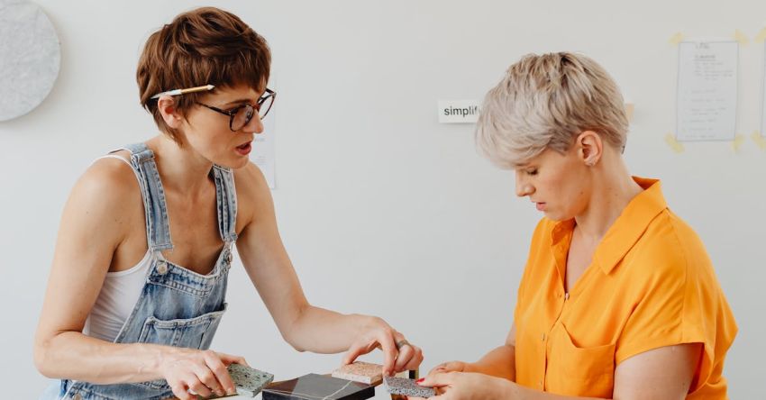 Matching Furniture - Woman in Orange Shirt and Woman in Blue Denim Overall Matching Pieces of Marble to Golden Stand