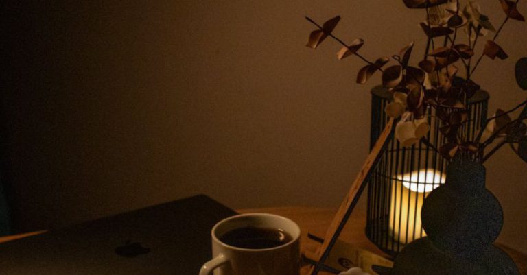 Table Candles - A laptop on a table with a candle and a cup of coffee