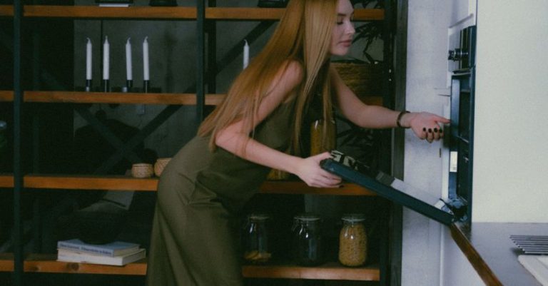 Industrial Style - Woman in Green Silk Dress Opening Oven Door in Kitchen